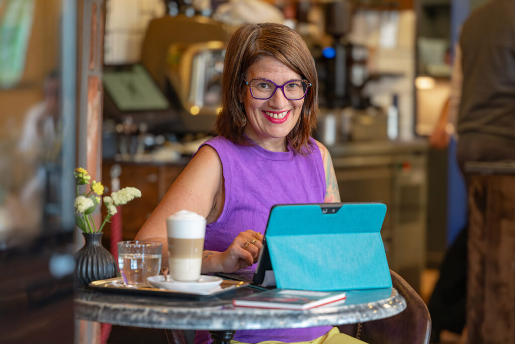 Vivien Schulter arbeitet im Café an KI-Lösungen für KMUs und erklärt moderne, praxisnahe Anwendungen.